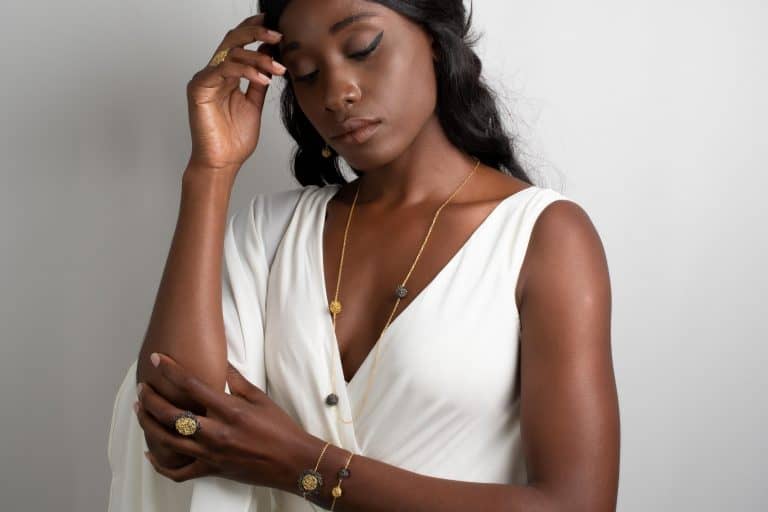 model wearing long pendant necklace in gold color